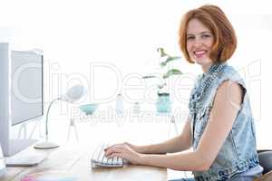smiling hipster woman sitting at her computer