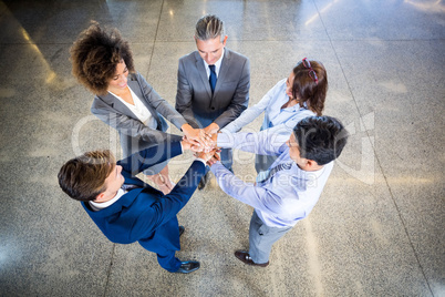 Businesspeople standing with their hands stacked