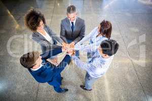 Businesspeople standing with their hands stacked