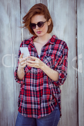 beautiful hipster woman looking at her mobile phone