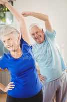 Senior couple performing stretching exercise