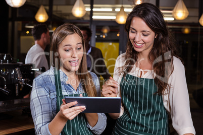 Pretty baristas using tablet