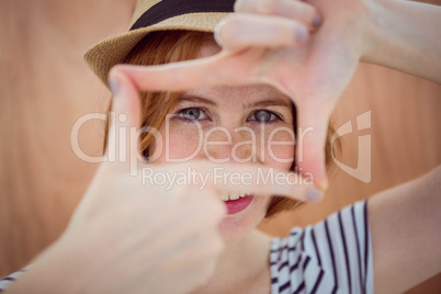 Blue eyed hipster looking through her hands