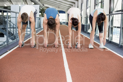 Four athletic women and men stretching