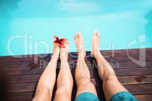Couple bare feet against swimming pool