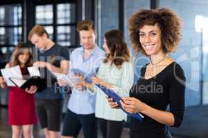 Portrait of smiling woman holding clipboard