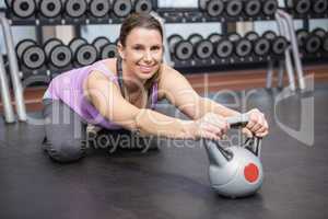 Smiling woman exercising with kettlebell