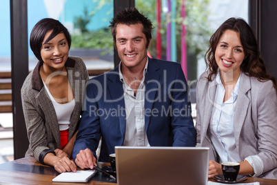 Smiling people using laptop together