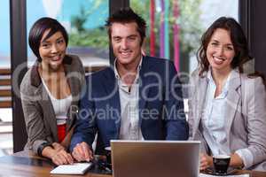 Smiling people using laptop together