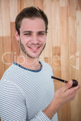 Handsome hipster smoking pipe