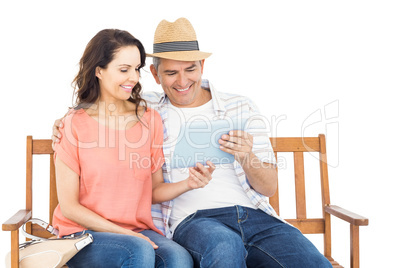 Couple on bench using tablet