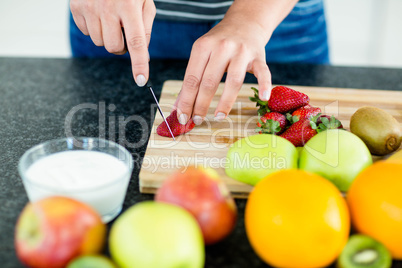 Woman cutting fruits on chopping board