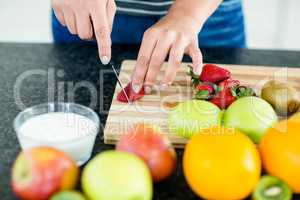 Woman cutting fruits on chopping board