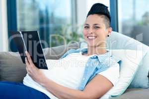 portrait of pregnant woman holding notepad