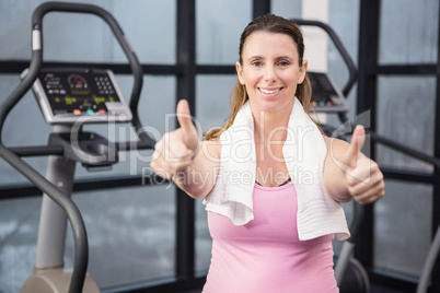Happy pregnant woman showing thumbs up