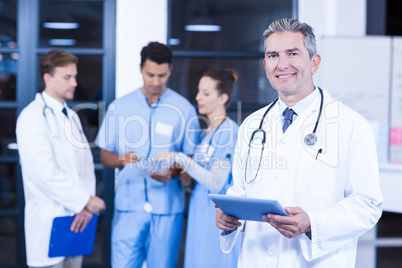 Doctor holding digital tablet and smiling at camera