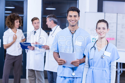 Doctor holding medical report and smiling at camera