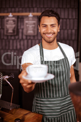 Smiling barista holding espresso
