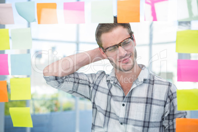 Thoughtful hipster man with post-it