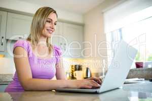 Pretty blonde woman having coffee and using laptop