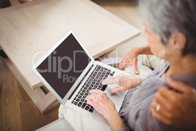 Senior woman using laptop in living room