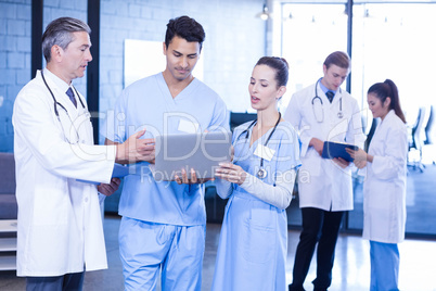 Medical team using laptop, digital tablet and examining medical