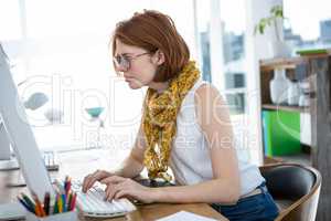 thoughtful hipster businesswoman concentrating on her computer
