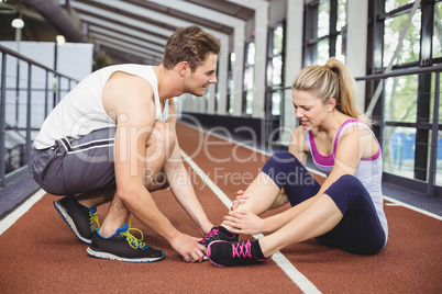 Muscular woman having an ankle injury