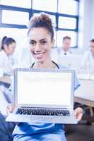 Portrait of female doctor showing laptop