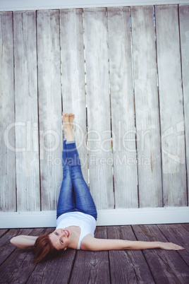 smiling hipster woman with her legs against the wall