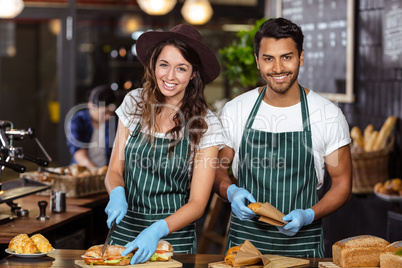 Smiling baristas preparing sandwiches