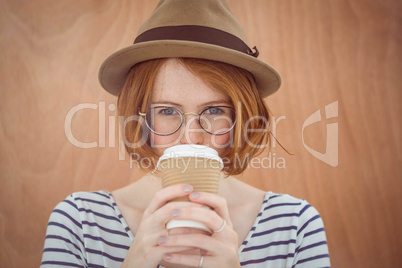 Cute red haired hipster with glasses holding disposable cup