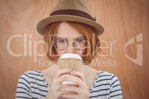Cute red haired hipster with glasses holding disposable cup