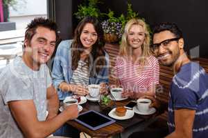 Smiling friends enjoying coffee together