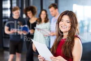 Portrait of woman holding a document in office