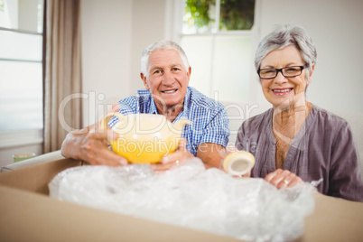 Senior couple unpacking a cardboard box