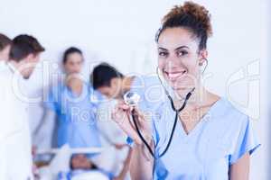 Female doctor showing stethoscope towards camera