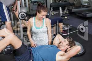 Trainer woman helping man doing her crunches