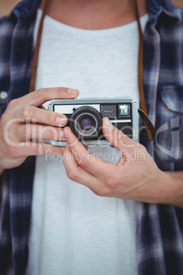 View of masculine hands holding a retro camera