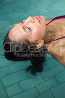 Peaceful woman floating in the pool
