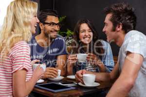 Smiling friends enjoying coffee together