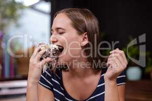 Pretty woman eating piece of cake with hand