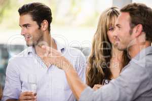 Friends having champagne and talking to each other