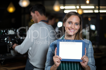 Pretty barista showing tablet screen at the camera