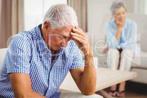 Worried senior man sitting on sofa