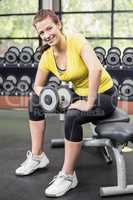 Smiling woman working out with dumbbells