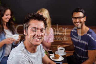 Smiling friends enjoying coffee together