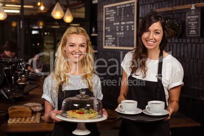 Pretty waitresses posing in front of the counter presenting coff