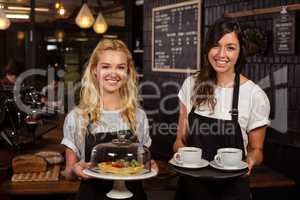 Pretty waitresses posing in front of the counter presenting coff
