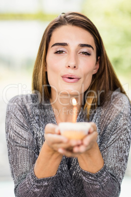 Beautiful woman holding birthday cupcake